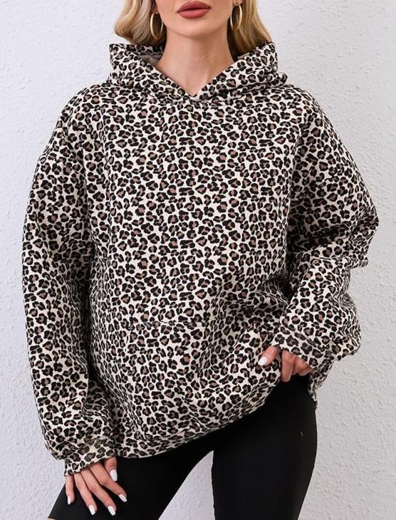 Person wearing a leopard print hoodie against a plain background