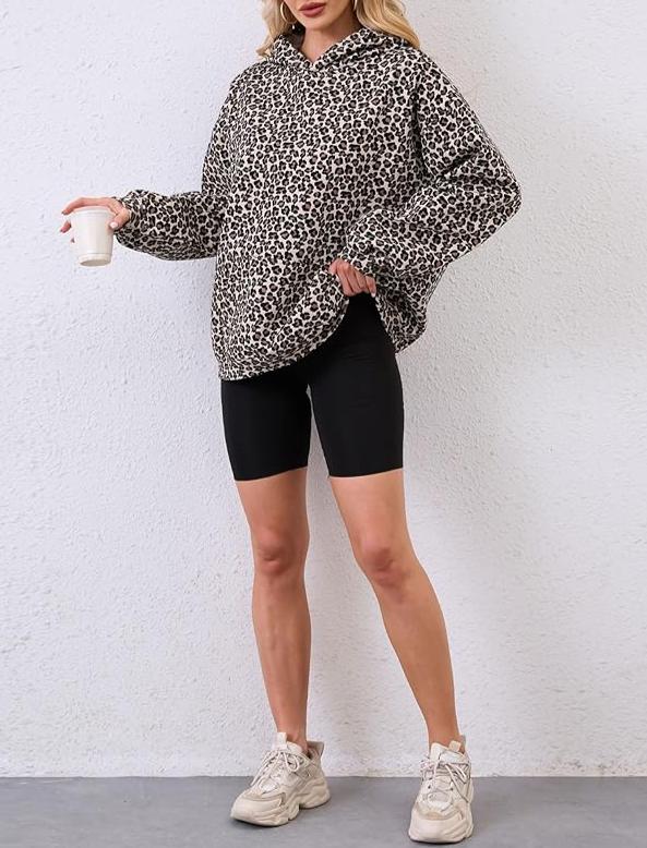 Person wearing a leopard print hoodie and black shorts against a white background