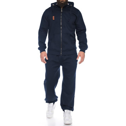 Person wearing a navy tracksuit with a white background