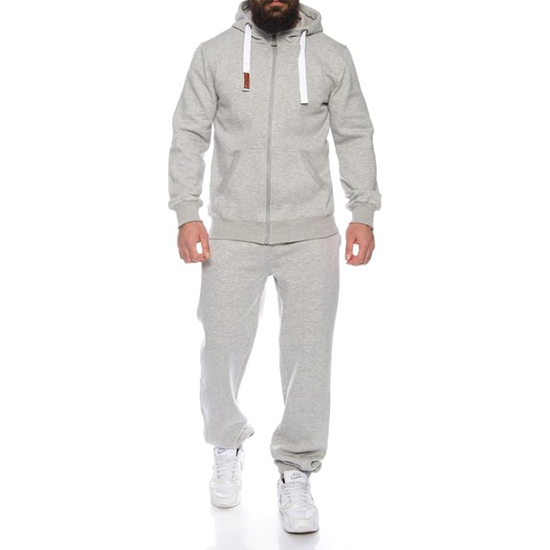 Person wearing a gray tracksuit with a white background