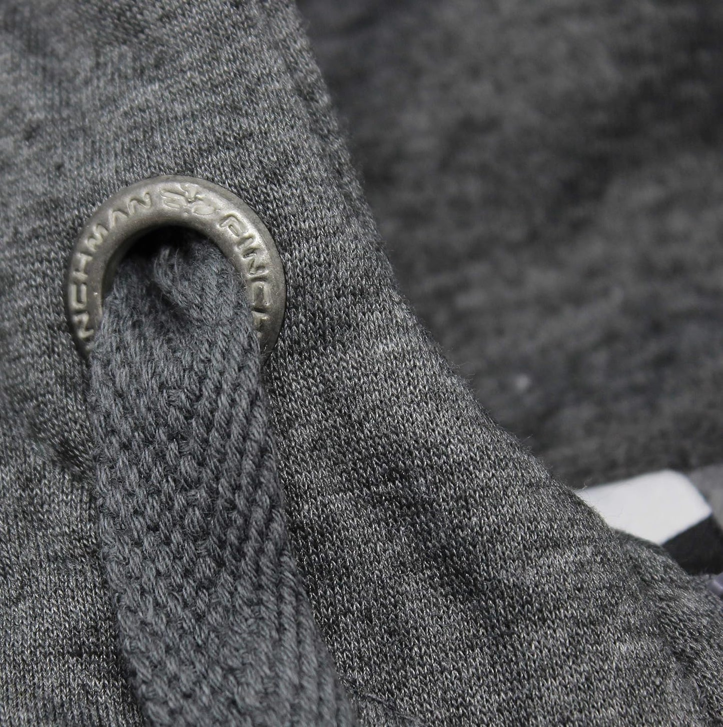 Close-up of a textured gray fabric with a metal ring and 'Norseman' branding.