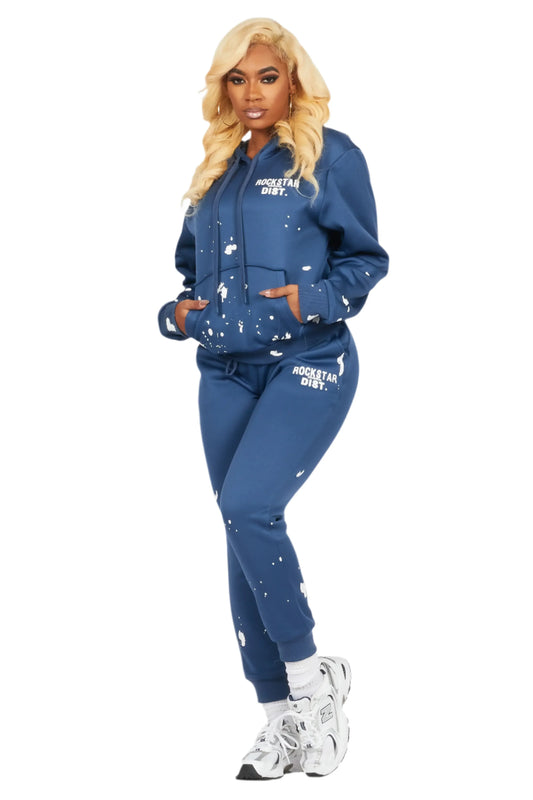 Woman wearing a blue tracksuit with white text and designs on a white background