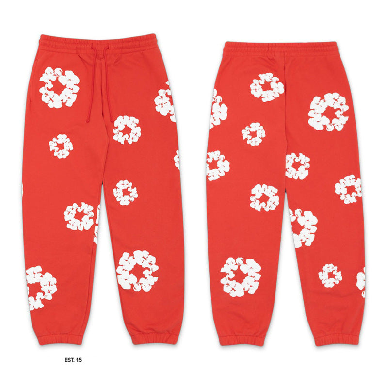 Red sweatpants with white floral patterns on a white background