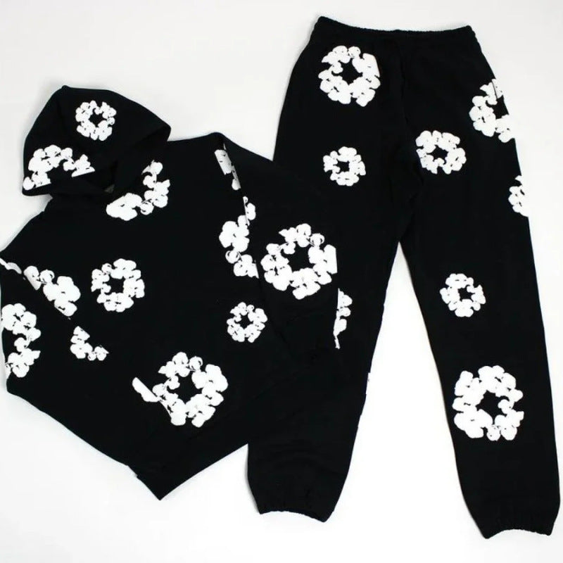 Black hoodie and pants with white floral patterns on a white background