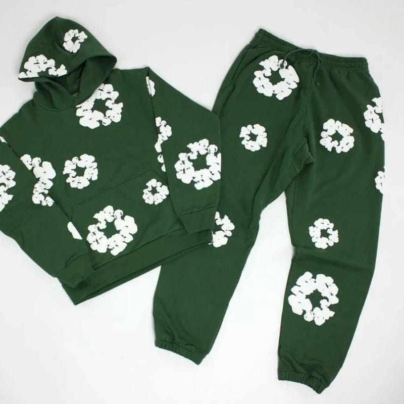 Green hoodie and pants set with white floral patterns on a white background