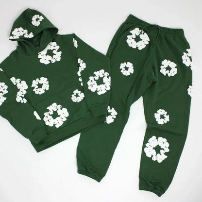 Green hoodie and pants set with white floral patterns on a white background