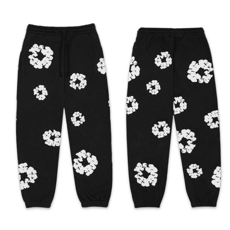 Black sweatpants with white floral patterns on a white background