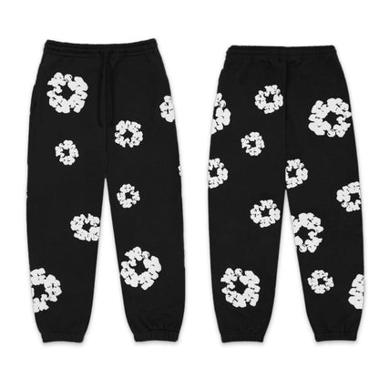 Black sweatpants with white floral patterns on a white background