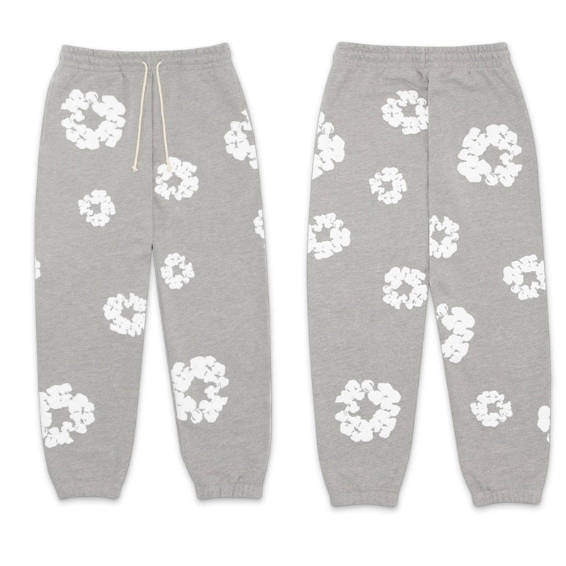 Gray sweatpants with white floral patterns on a white background