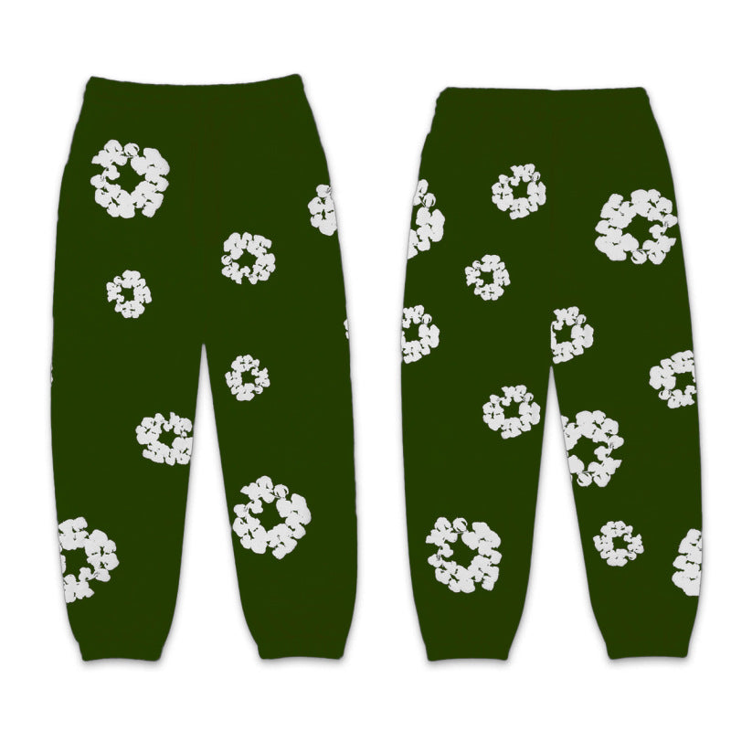 Green pants with white floral patterns on a white background