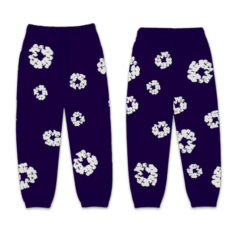 Pair of purple pants with white floral patterns on a white background