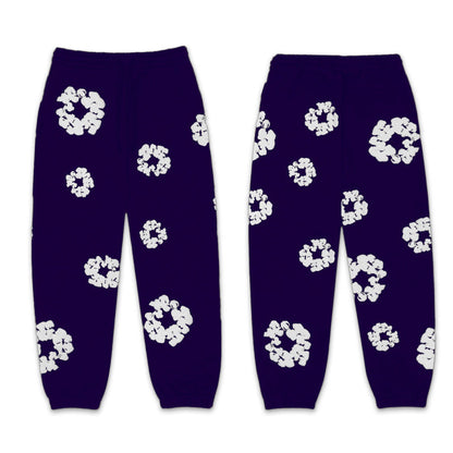 Pair of purple pants with white floral patterns on a white background