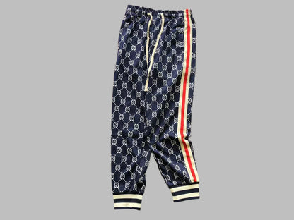 Navy blue pants with white logo pattern and red and yellow stripes on a gray background