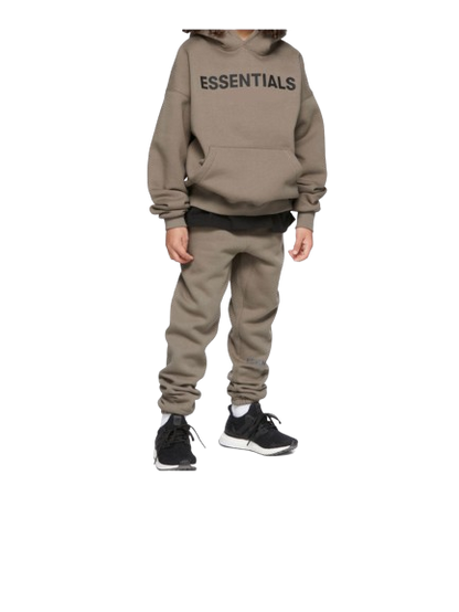 Person wearing a beige 'ESSENTIALS' hoodie and pants on a white background