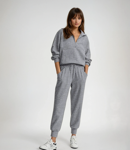 Woman wearing a gray tracksuit on a white background