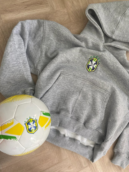 Gray hoodie with a logo and a soccer ball on a wooden floor