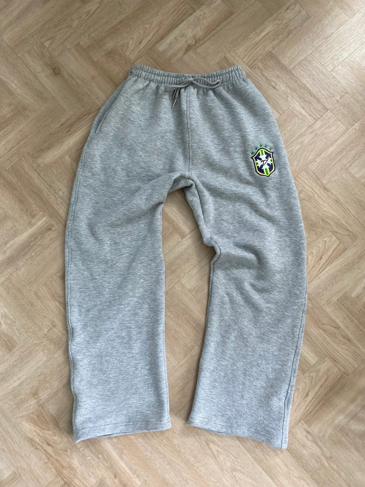 Gray sweatpants with a logo on a wooden floor