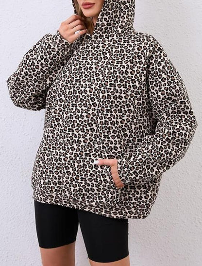 Person wearing a leopard print hoodie against a white background