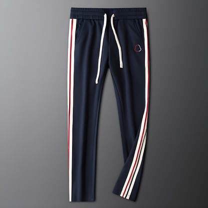 Navy blue track pants with white and red stripes on a gray background