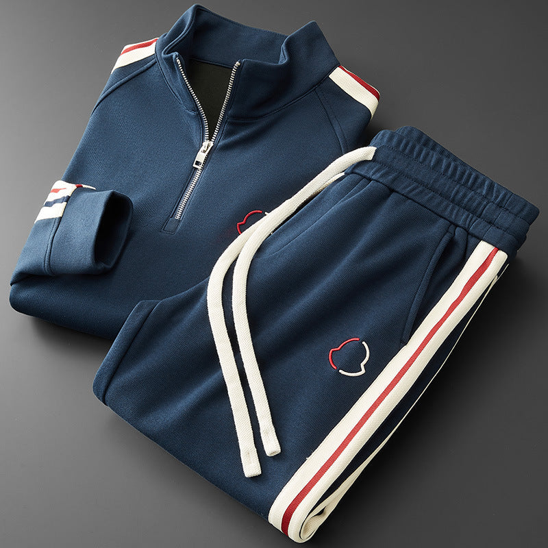 Navy tracksuit with white and red accents on a dark background