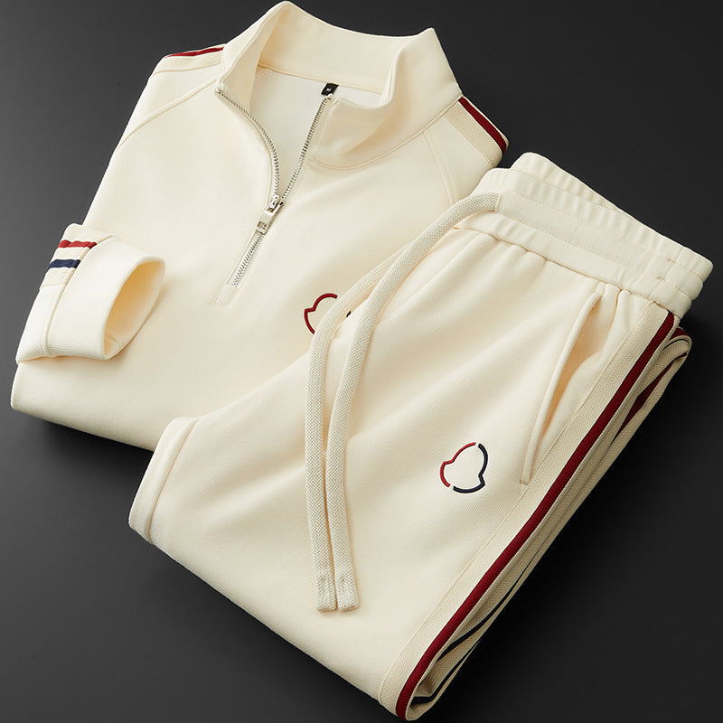 Cream-colored tracksuit with red and blue accents on a dark background