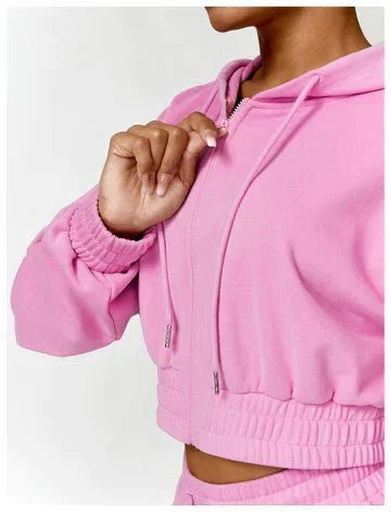 Person wearing a pink hoodie with a close-up of the zipper area.
