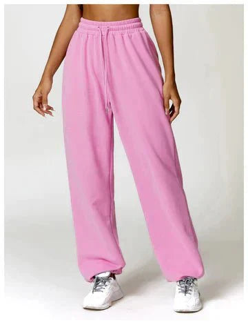Person wearing pink sweatpants on a white background