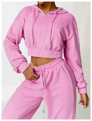 Person wearing a pink tracksuit on a white background