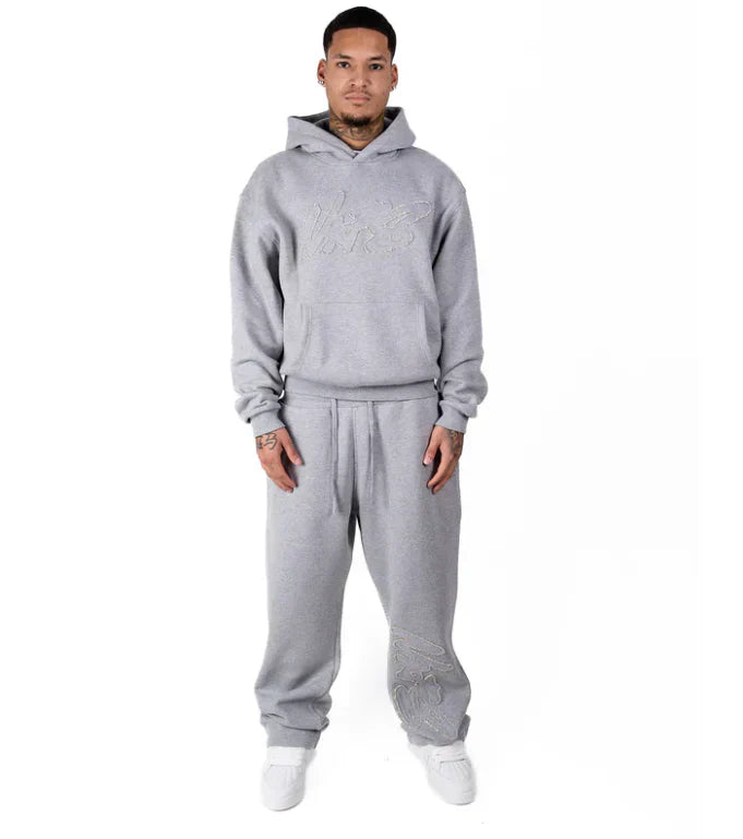 Person wearing a gray tracksuit on a white background