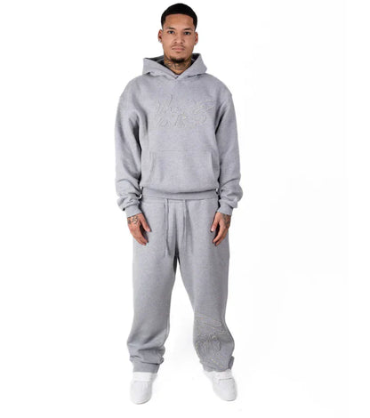Person wearing a gray tracksuit on a white background