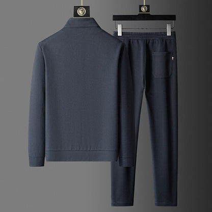 Navy blue tracksuit on hangers against a gray background