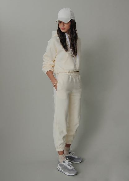 Person wearing a white outfit with a cap against a gray background