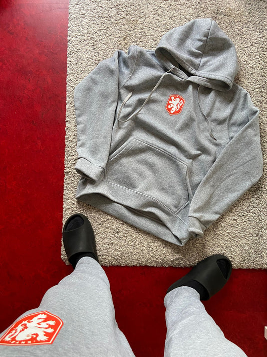 Gray hoodie with a red logo on a red floor