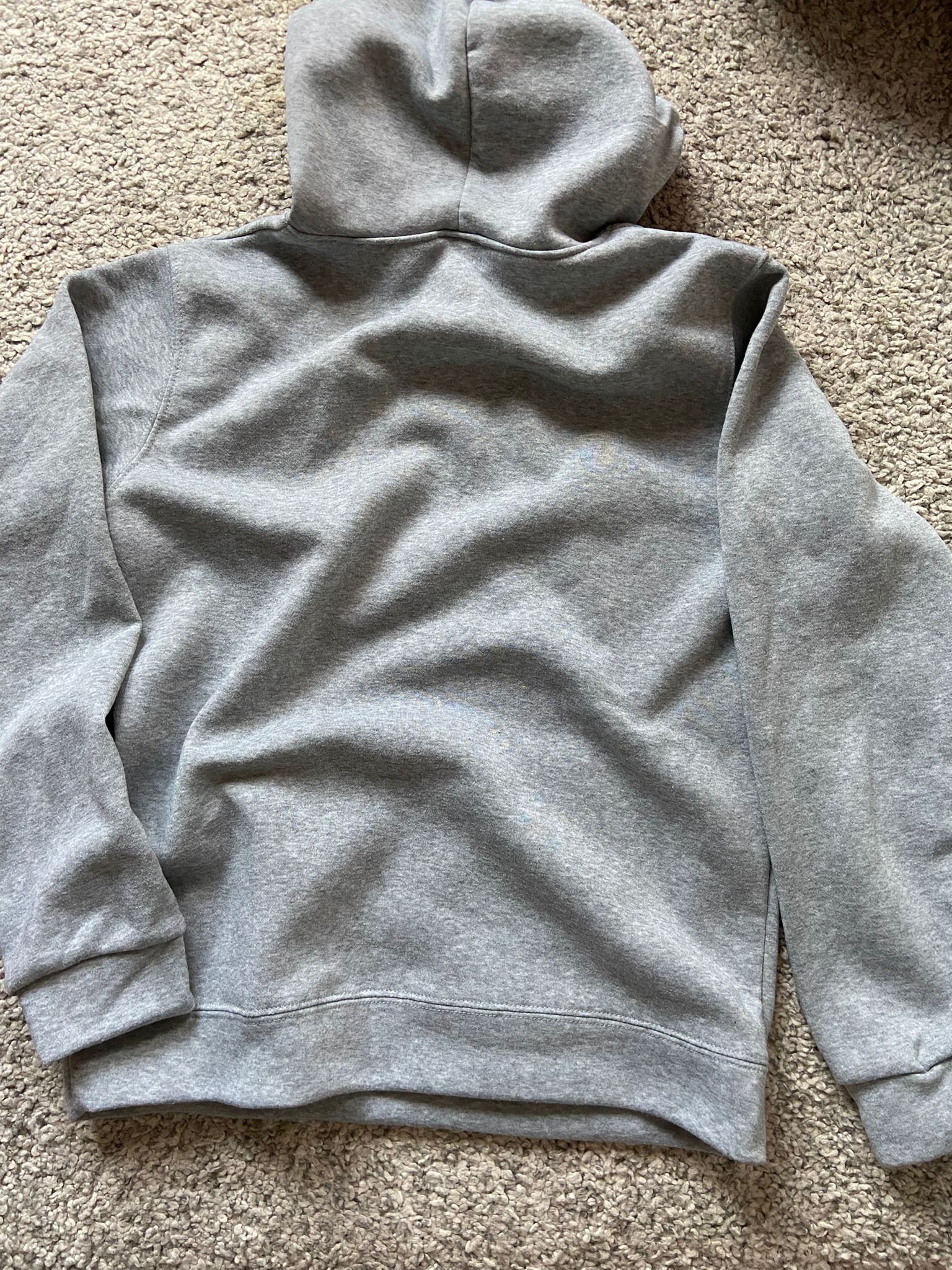 Gray hoodie on a beige carpet
