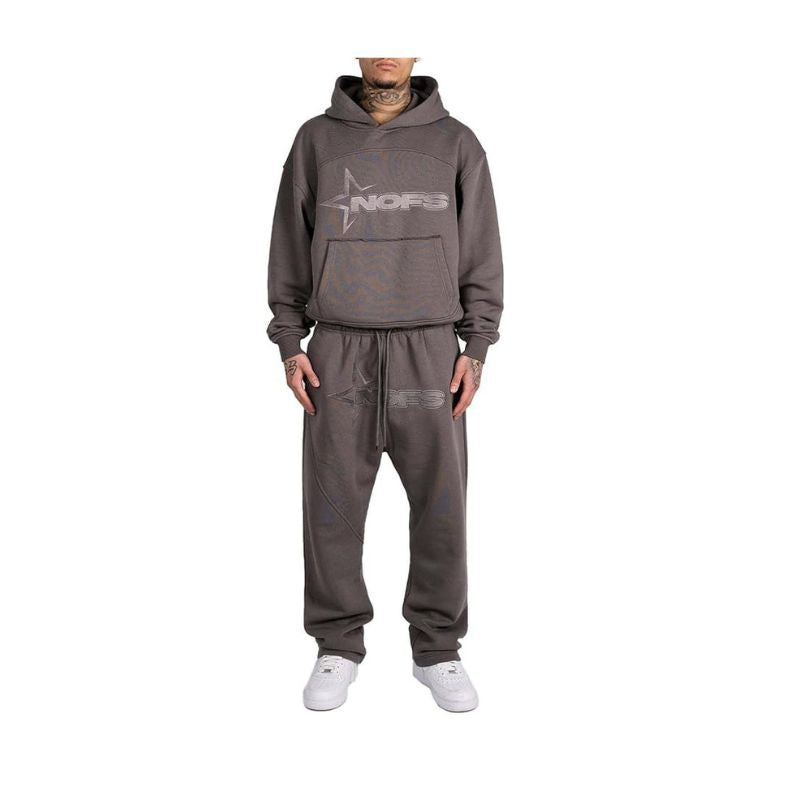 Person wearing a gray hoodie and pants set with a logo on a white background