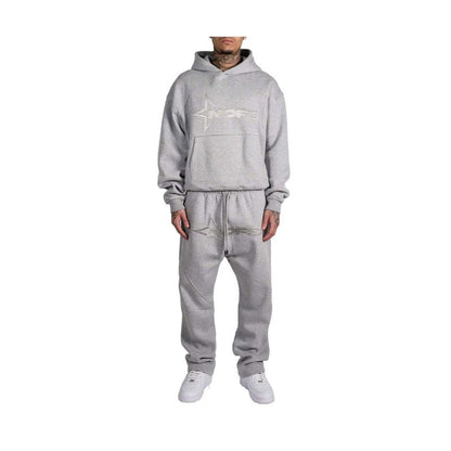 Person wearing a gray tracksuit with a logo on a white background