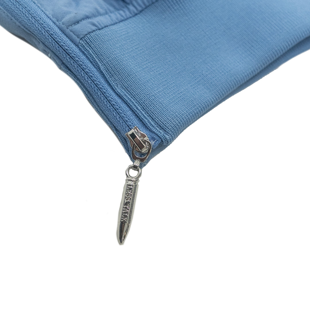 Close-up of a blue jacket zipper with a brand logo on a white background