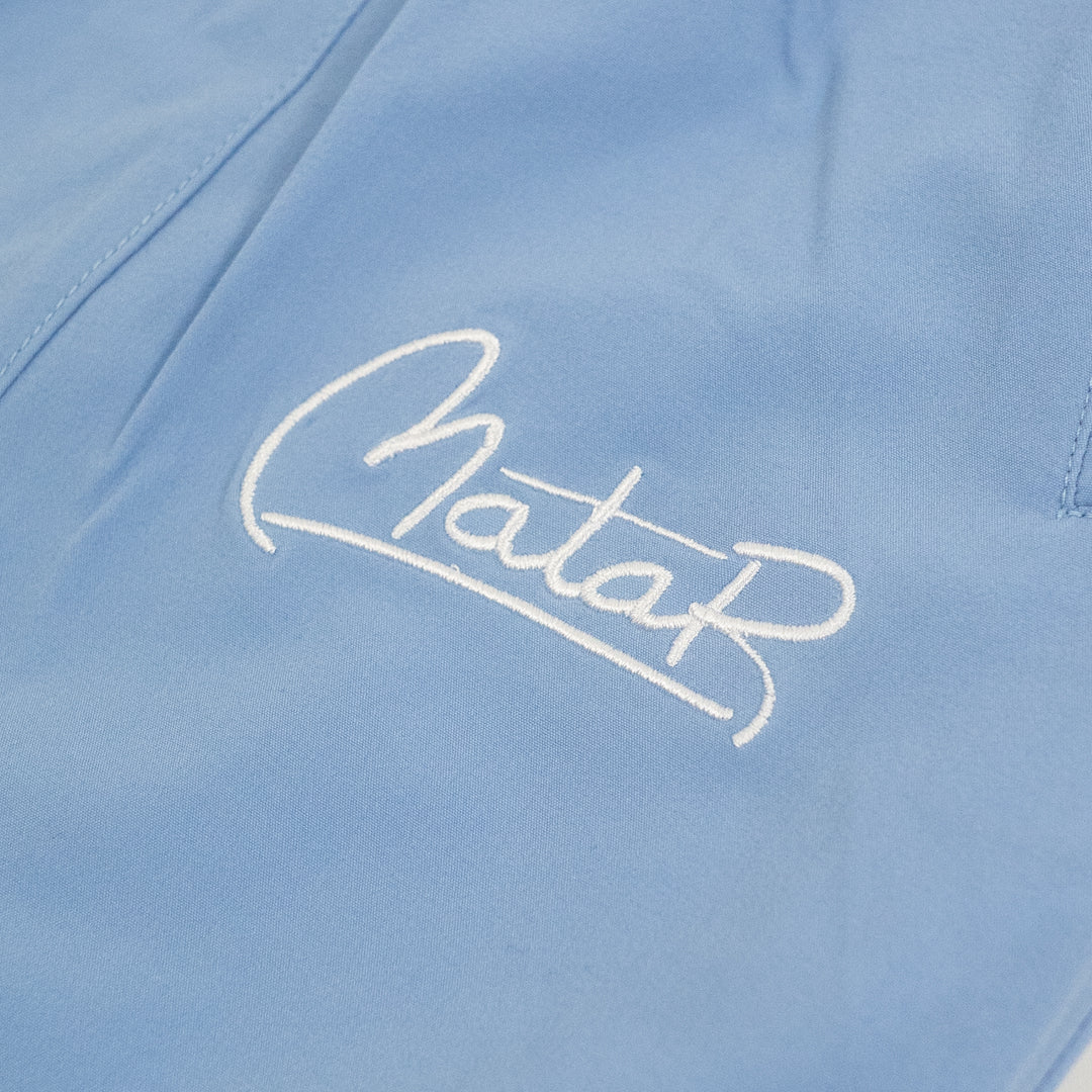 Close-up of a light blue fabric with 'Mata' embroidered in white.