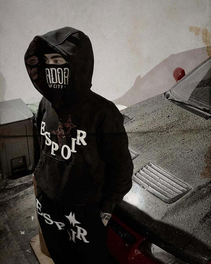 Person wearing a black hoodie with 'ESPOIR' branding in an urban setting.