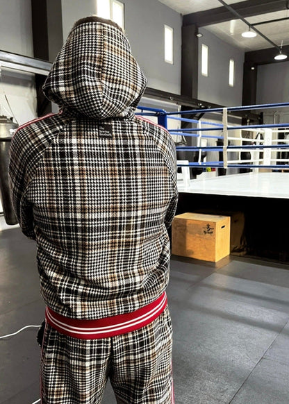 Person wearing a plaid tracksuit in a boxing ring area