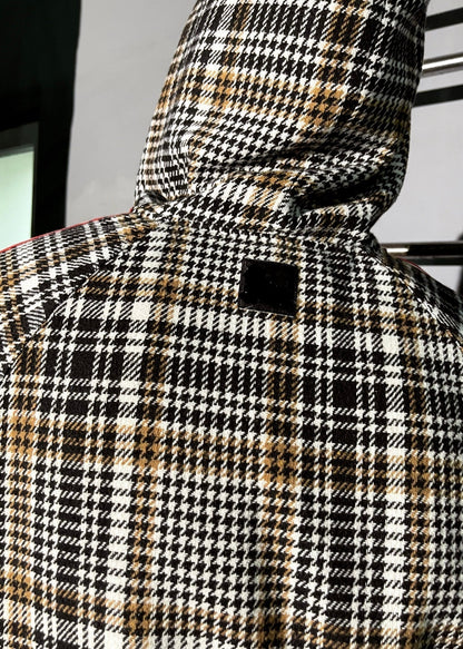 Houndstooth patterned coat with a hood on a neutral background