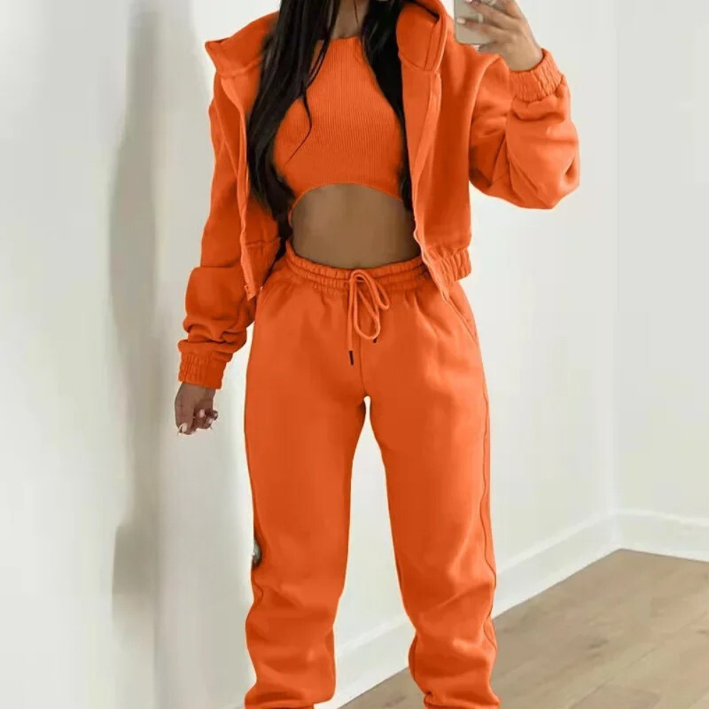 Person wearing an orange tracksuit against a white background