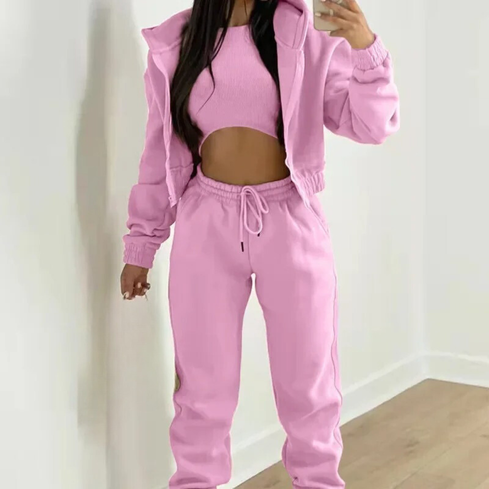 Person wearing a pink tracksuit against a white background