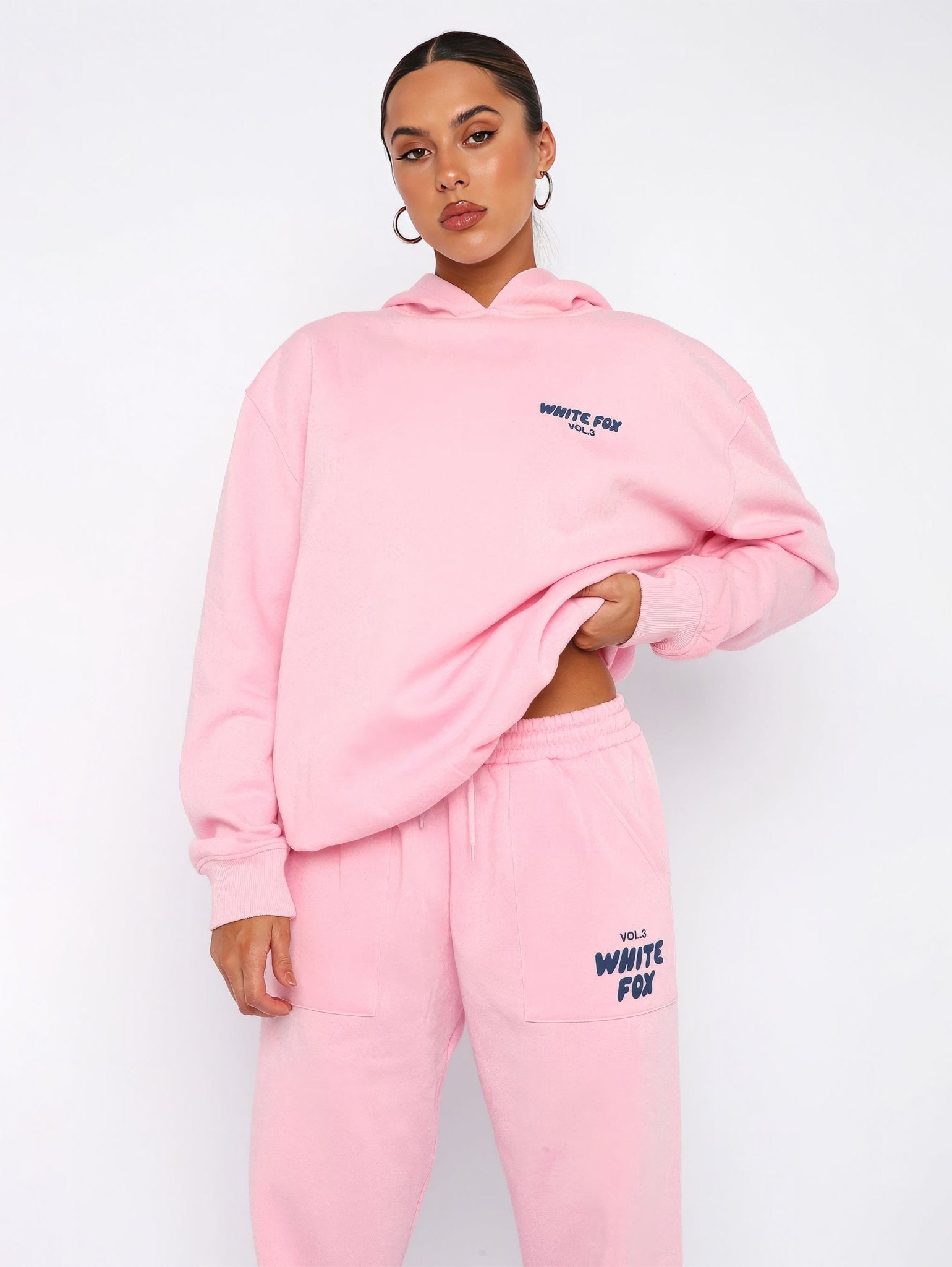 Person wearing a pink hoodie and pants with 'White Fox' branding on a white background