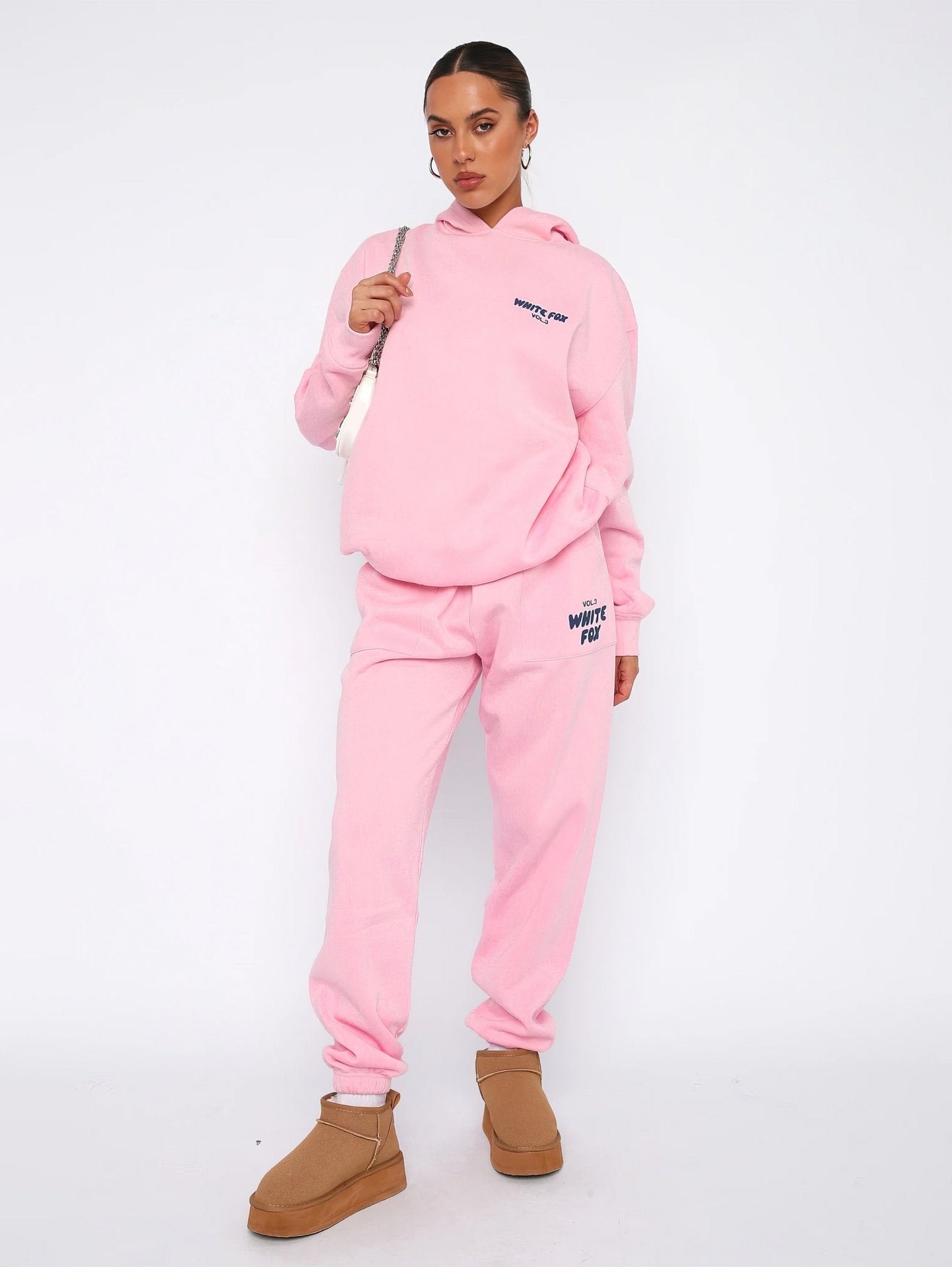 Person wearing a pink tracksuit with 'White Fire' branding on a white background