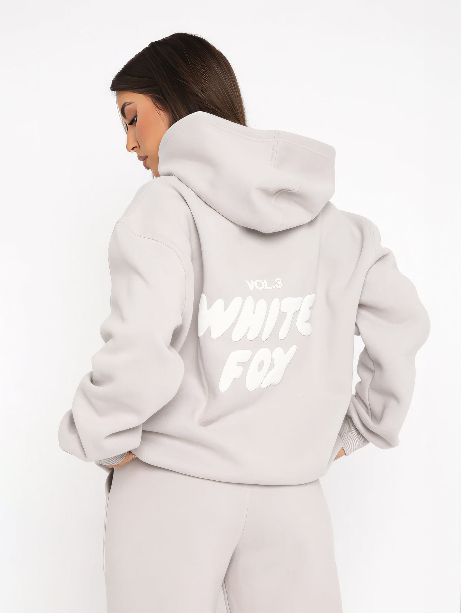 Person wearing a light gray hoodie with 'White Fox' text on the back against a white background