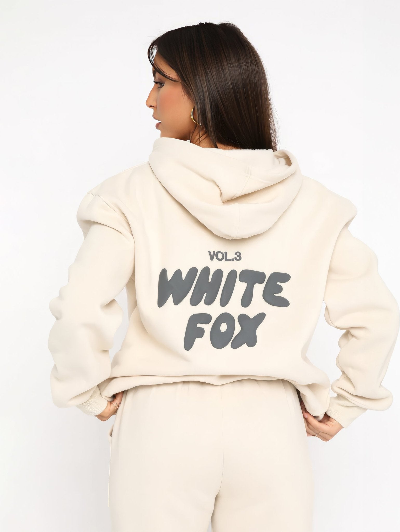 Person wearing a cream hoodie with 'White Fox' text on the back against a white background