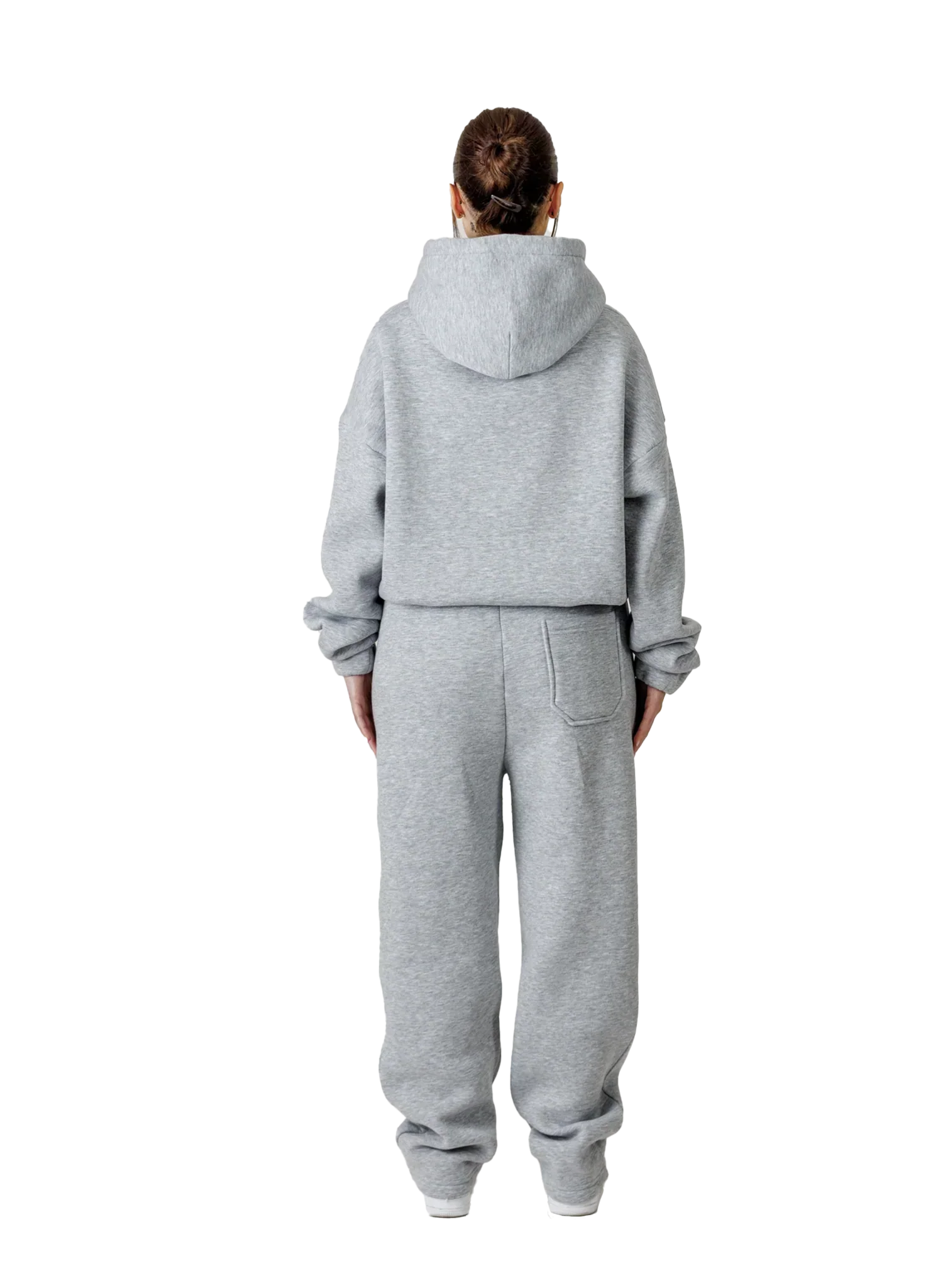 Person wearing a gray tracksuit on a white background