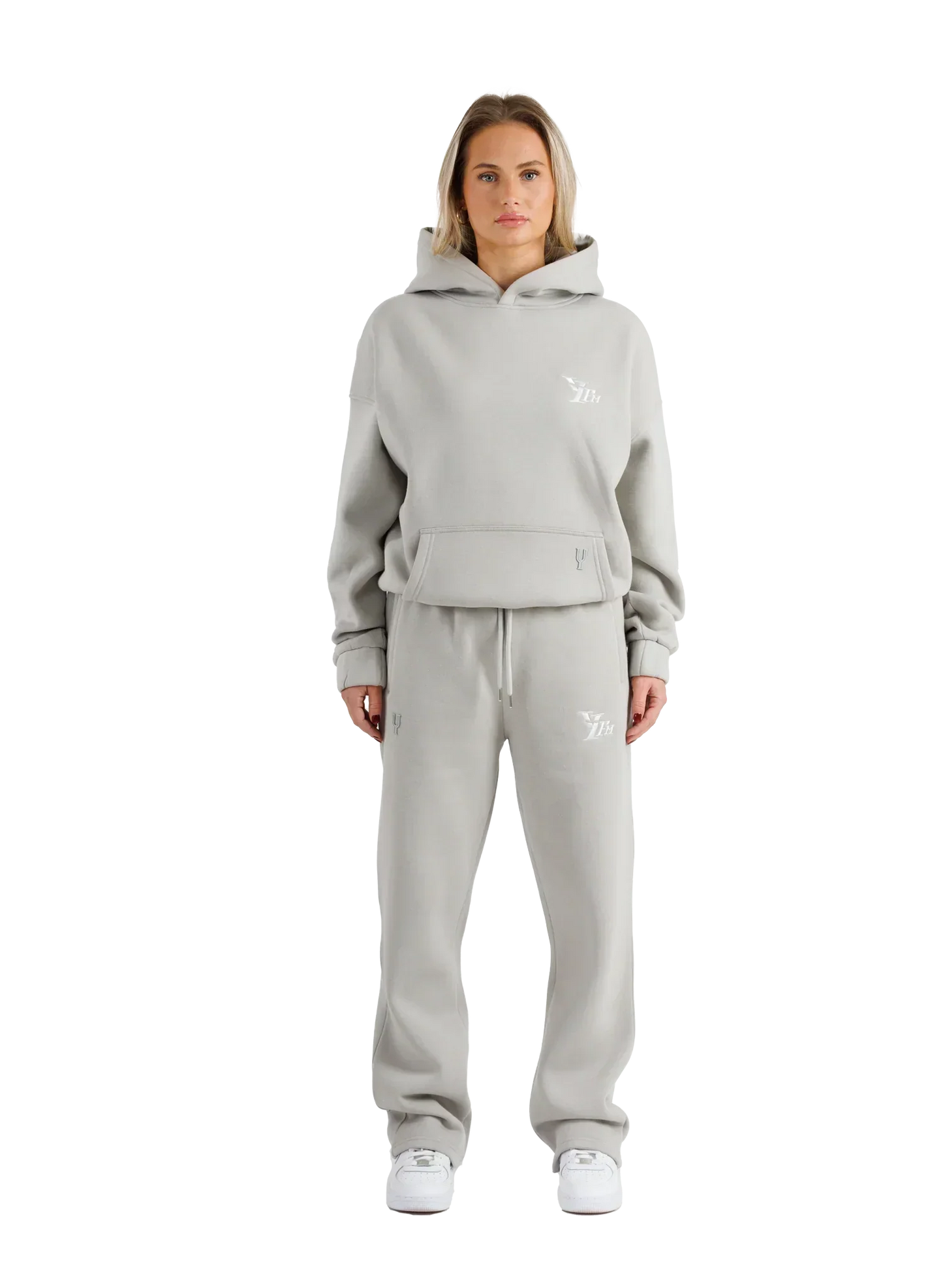 Woman wearing a gray tracksuit with a brand logo on a white background