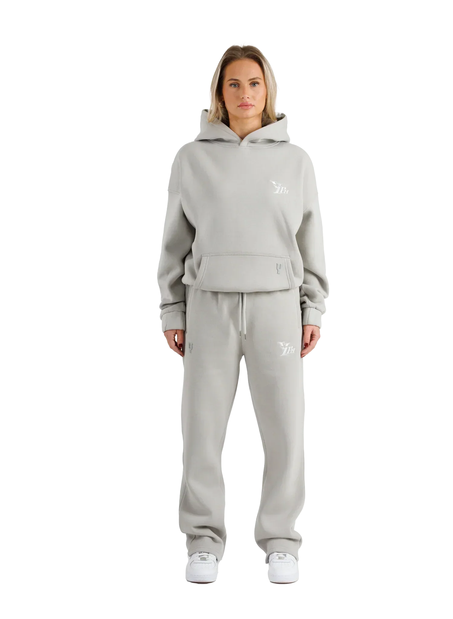 Woman wearing a gray tracksuit with a brand logo on a white background